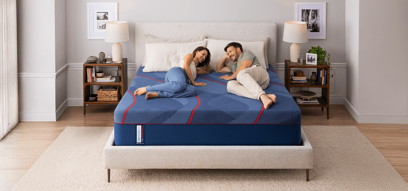 Couple laying on a Posturepedic Elite Hybrid High Point II mattress in styled room