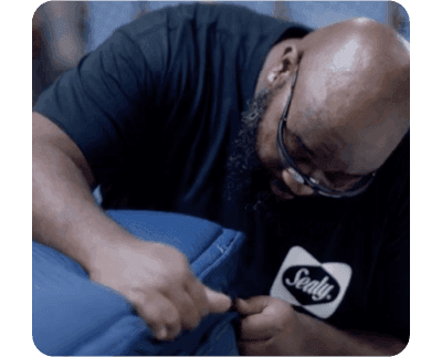 A man inspecting a Sealy mattress
