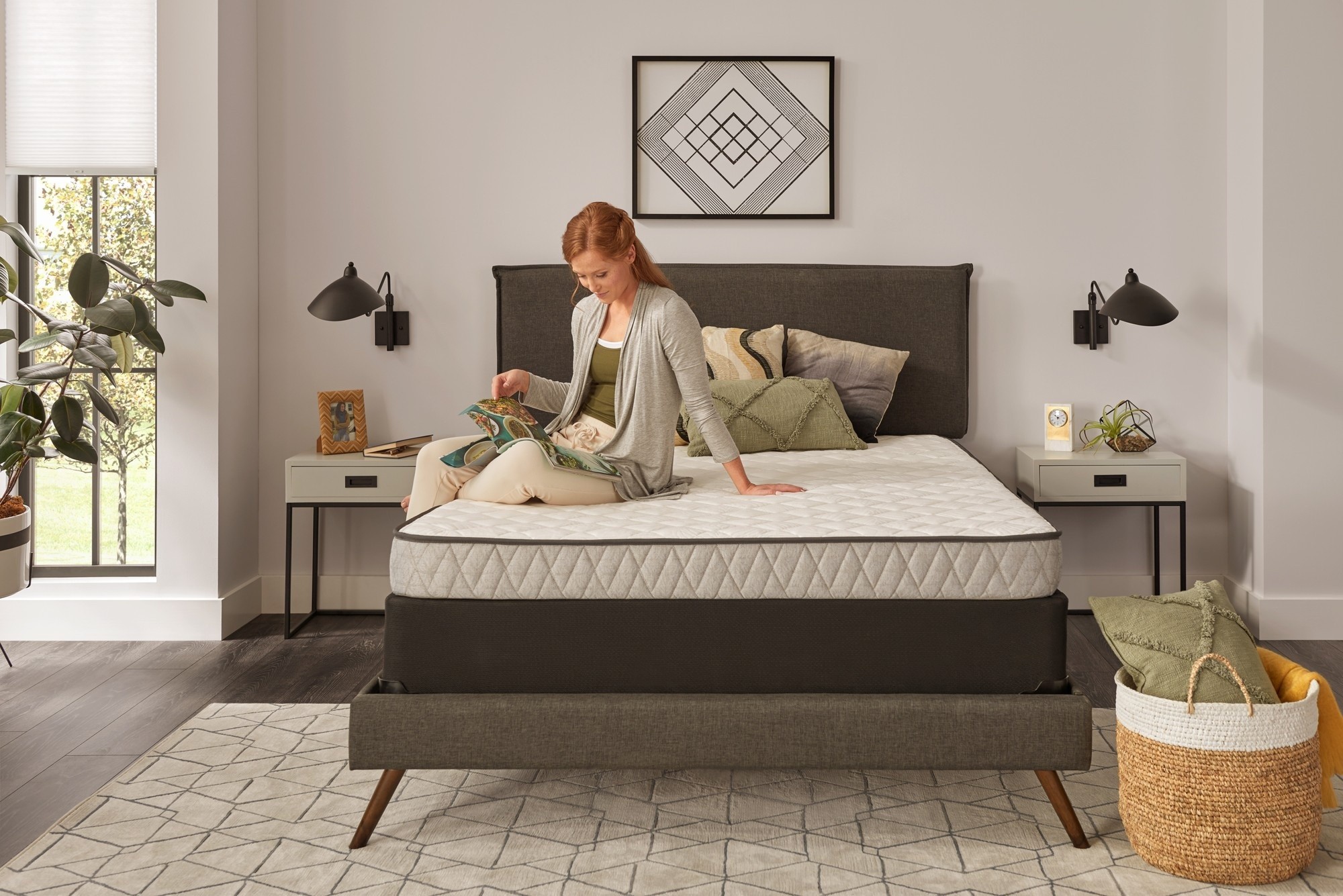 Woman reading on essentials spring 1 mattress