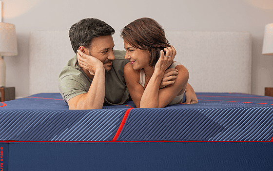 A couple laying on a Posturepedic Elite Hybrid mattress
